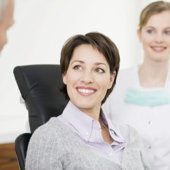 Smiling woman at consultation with healthcare professionals